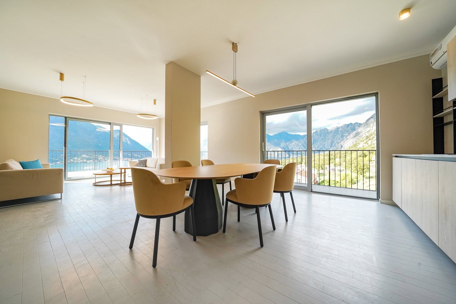 Modern living room with dining area and panoramic views of the mountains and sea in an apartment, Dobrota, Montenegro.