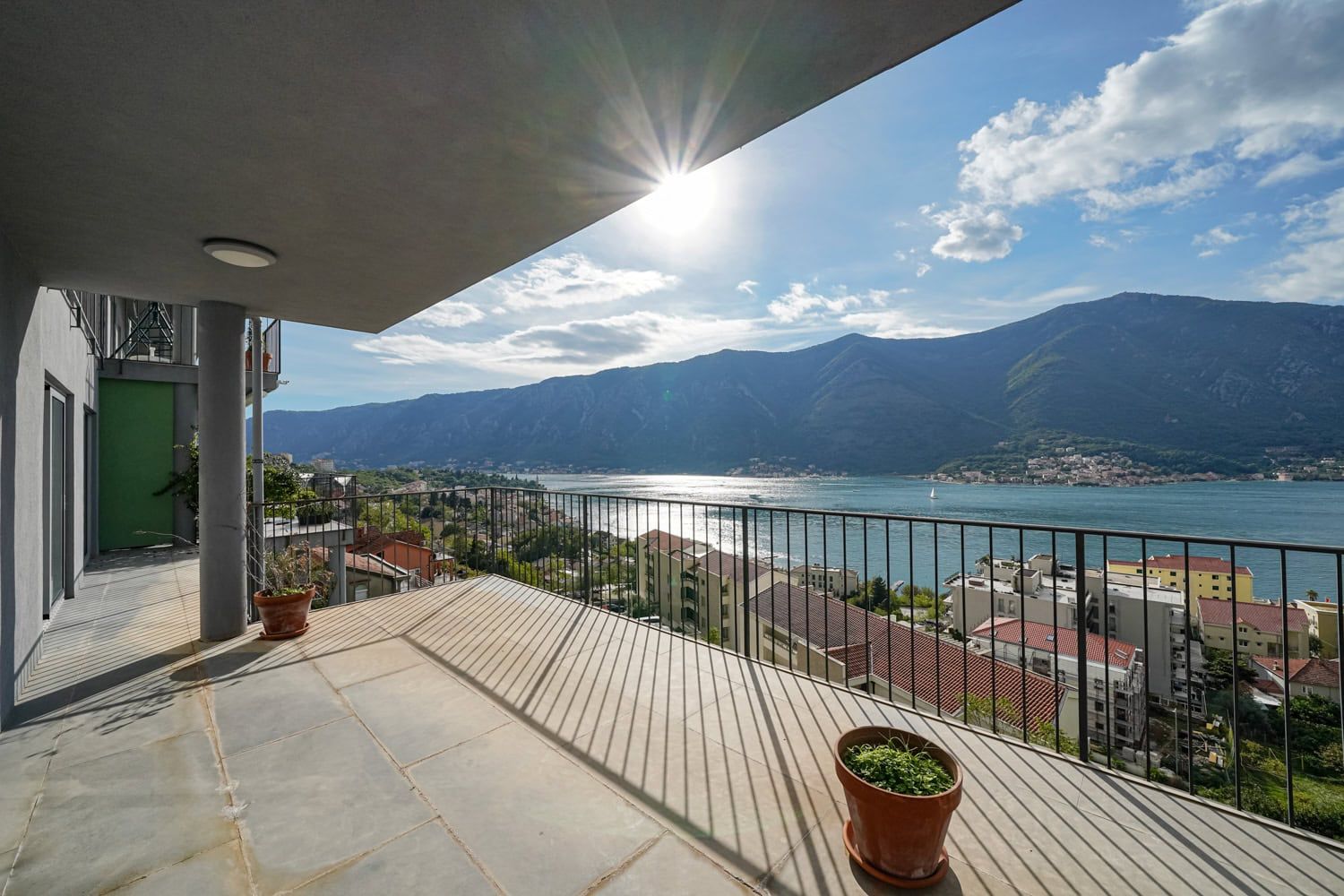 Spacious apartment terrace in Dobrota, Montenegro, with panoramic views of the Bay of Kotor and the mountains.