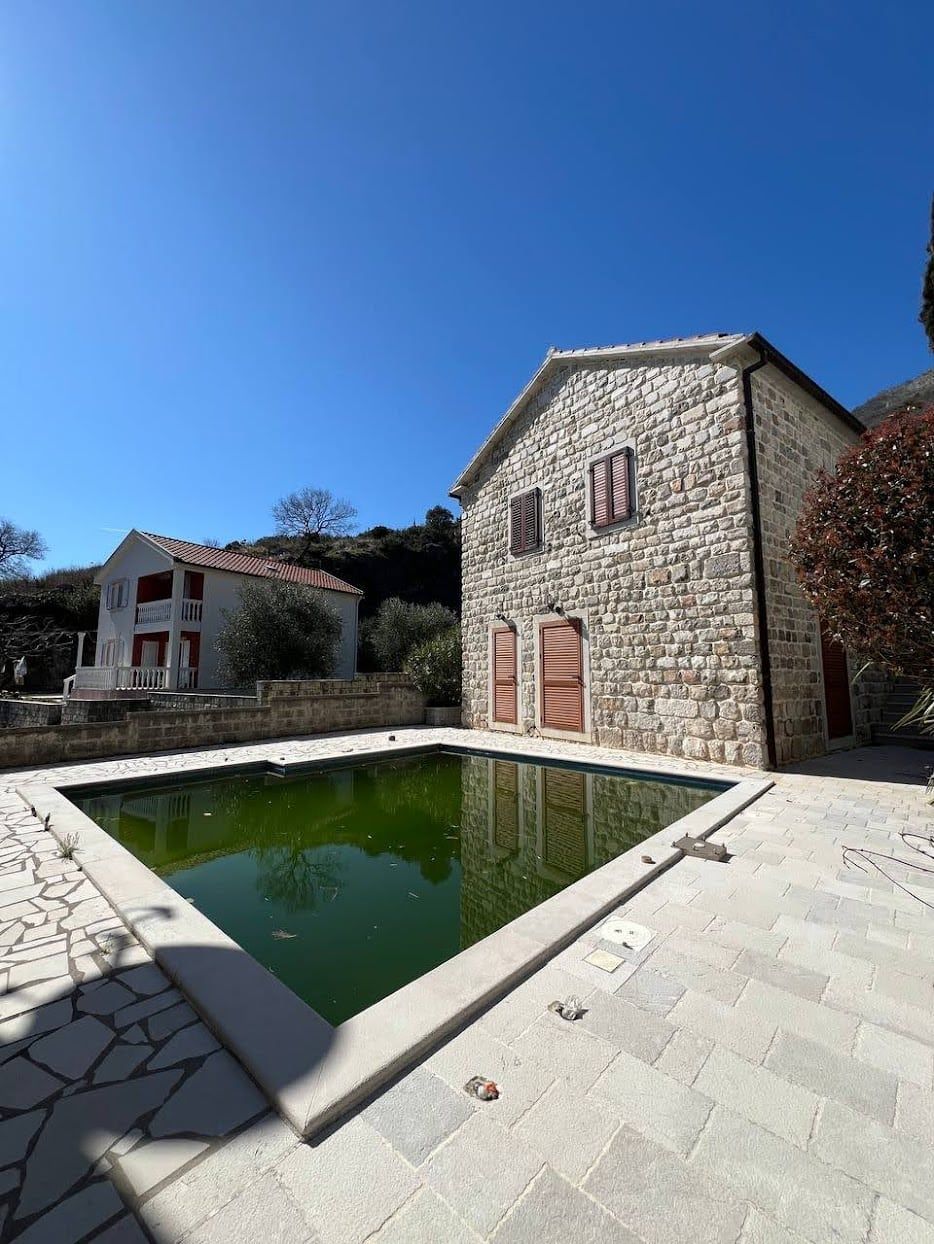 Stone villa with a pool and terrace in Kamenari, Montenegro: view of the house facade and the surrounding grounds.