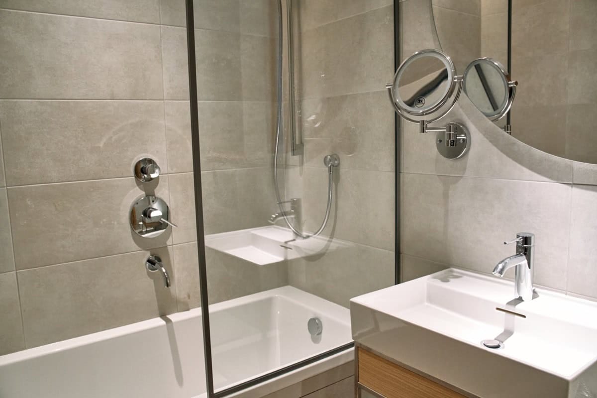 Modern bathroom in an apartment, Tivat, Montenegro: shower cabin, light tiles, and stylish fixtures.