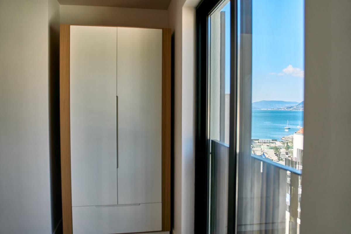 Modern wardrobe in the bedroom of an apartment in Tivat, Montenegro, with panoramic views of the sea and yacht marina.