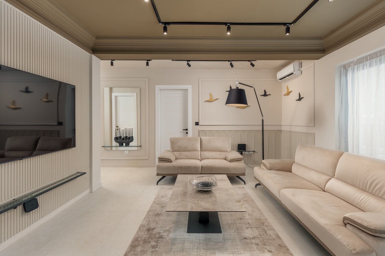 Modern living room with beige sofas and designer lighting in an apartment, Dobrota, Montenegro.