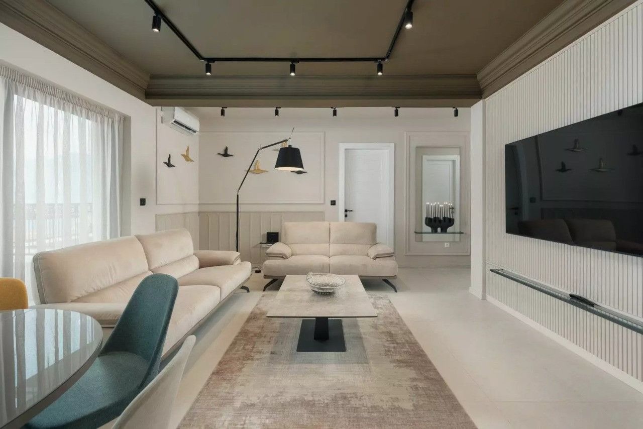 Modern living room with beige sofas and track lighting in an apartment, Dobrota, Montenegro.