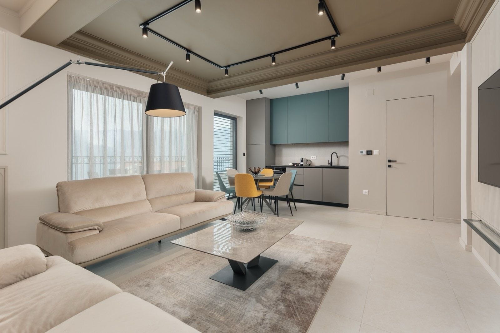 Modern living room with kitchen in an apartment in Dobrota, Montenegro: beige sofa, dining area, and stylish interior.