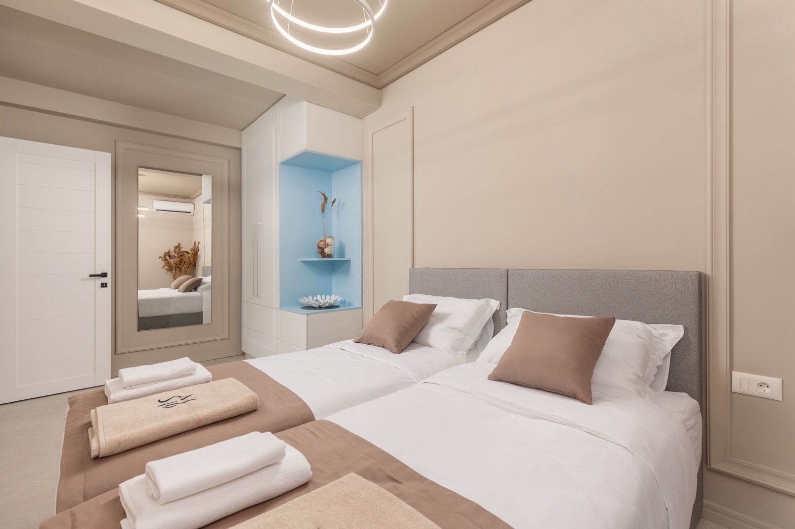 Modern bedroom with a double bed in an apartment in Dobrota, Montenegro: stylish interior, wardrobe and mirror.