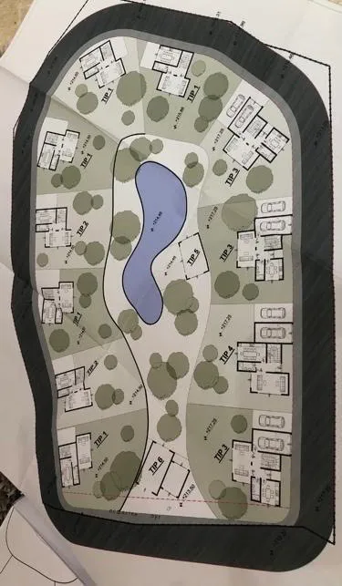 Architectural site plan showing house layouts, a pond, and landscaping.
