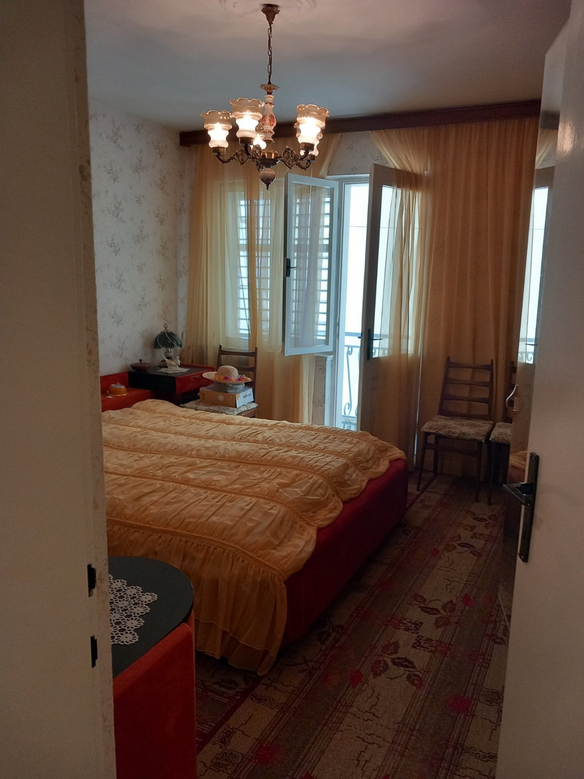 Cozy bedroom with a double bed and access to the balcony in a house, Igalo, Montenegro. Classic interior.