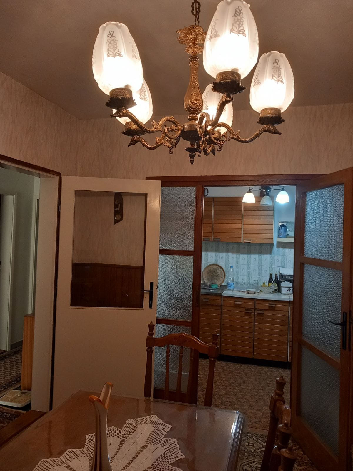 Living room interior with a classic chandelier and a view of the kitchen in a house, Igalo, Montenegro.