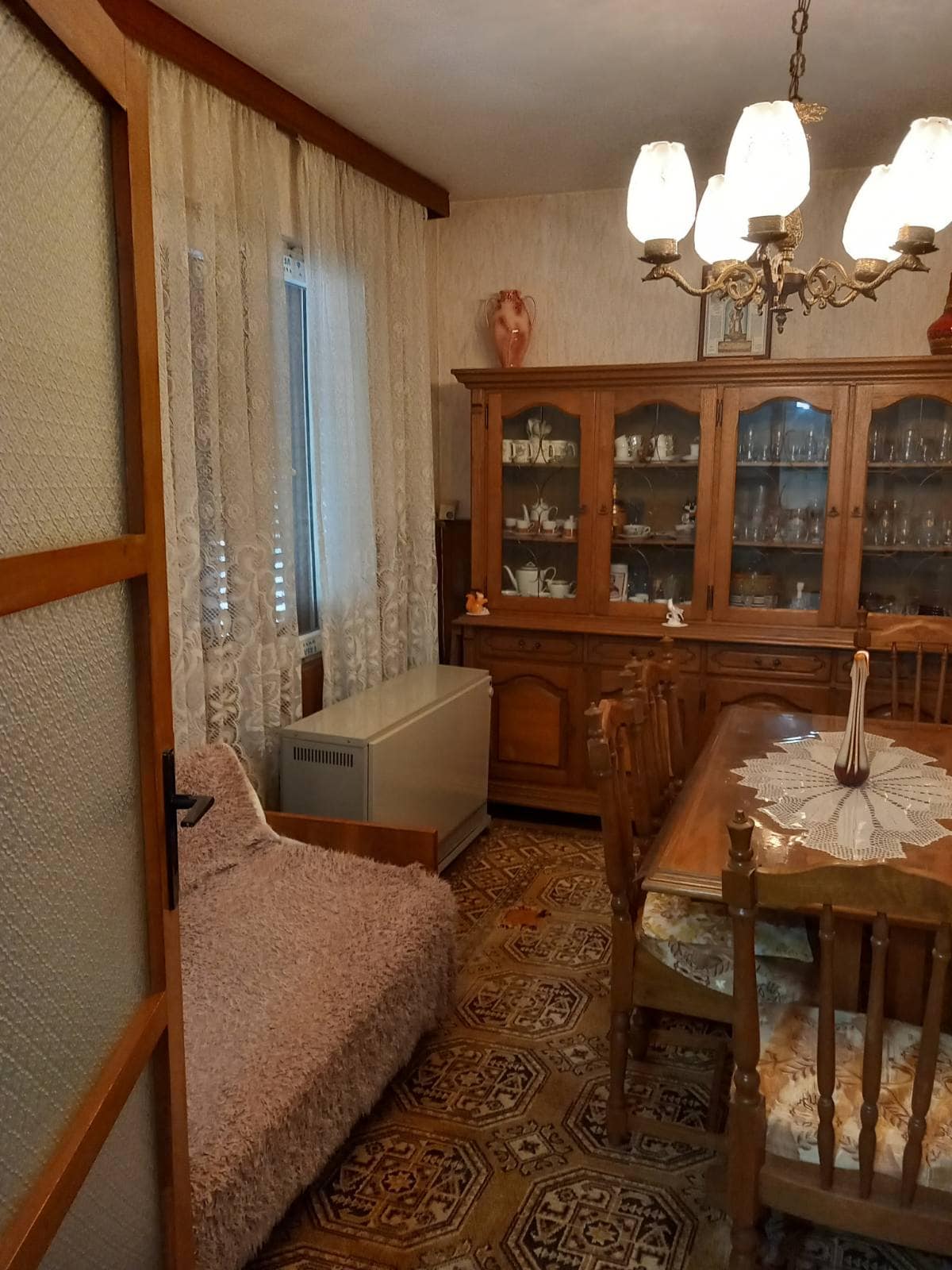 Classic living room with a wooden sideboard and dining area in a house, Igalo, Montenegro.