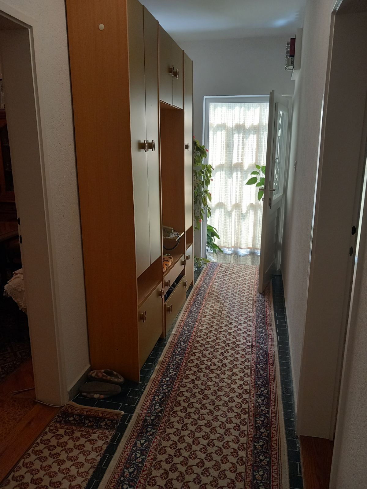 Hallway with a wooden wardrobe and runner in a house for sale in Igalo, Montenegro.
