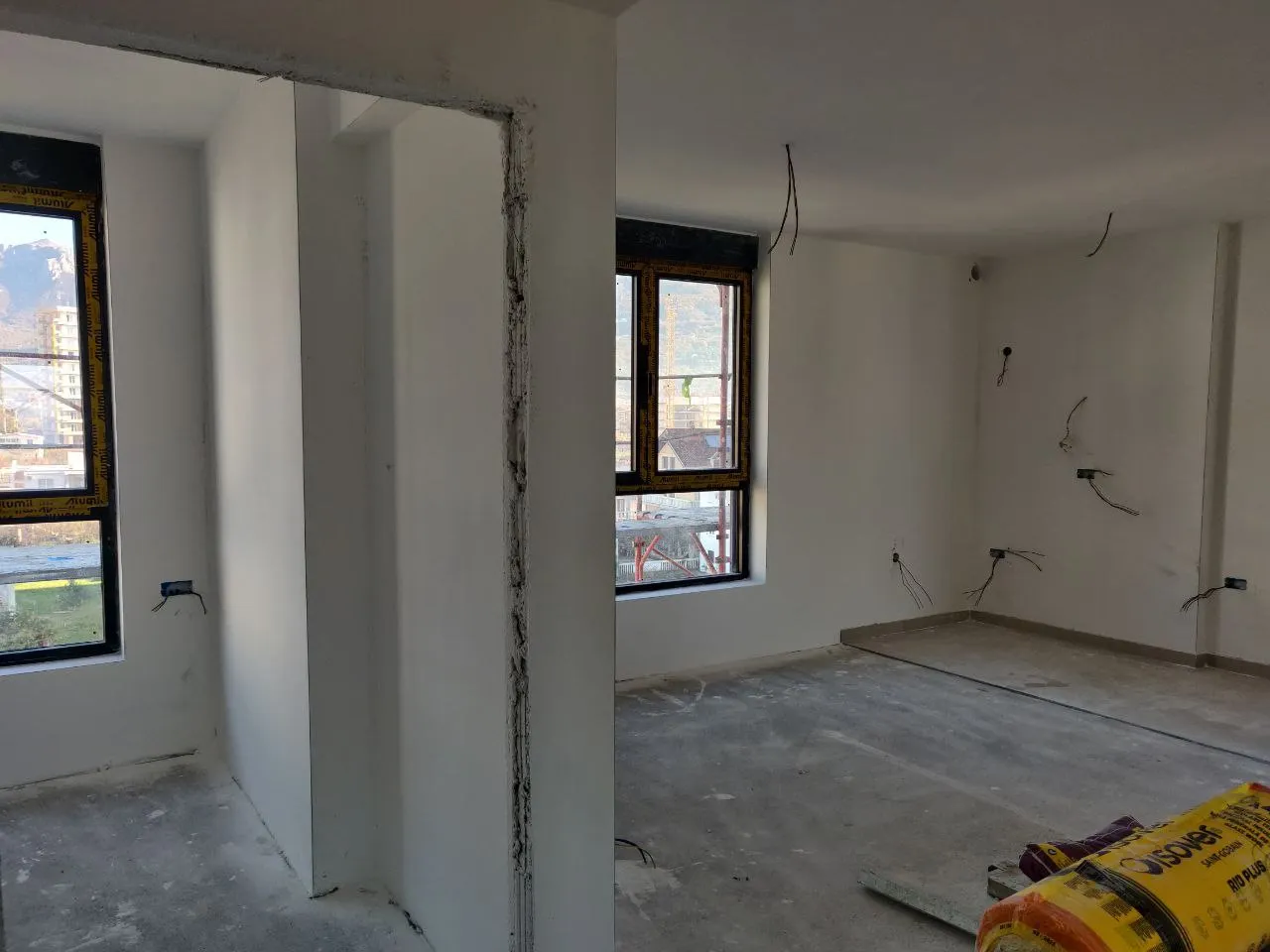 Room under construction with bare concrete floors, exposed wiring, and unfinished walls.