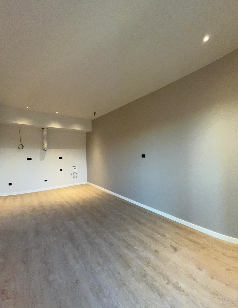 Living room with finished interior and laminate flooring in a new apartment in Tivat, Montenegro. Ready for appliance installation.