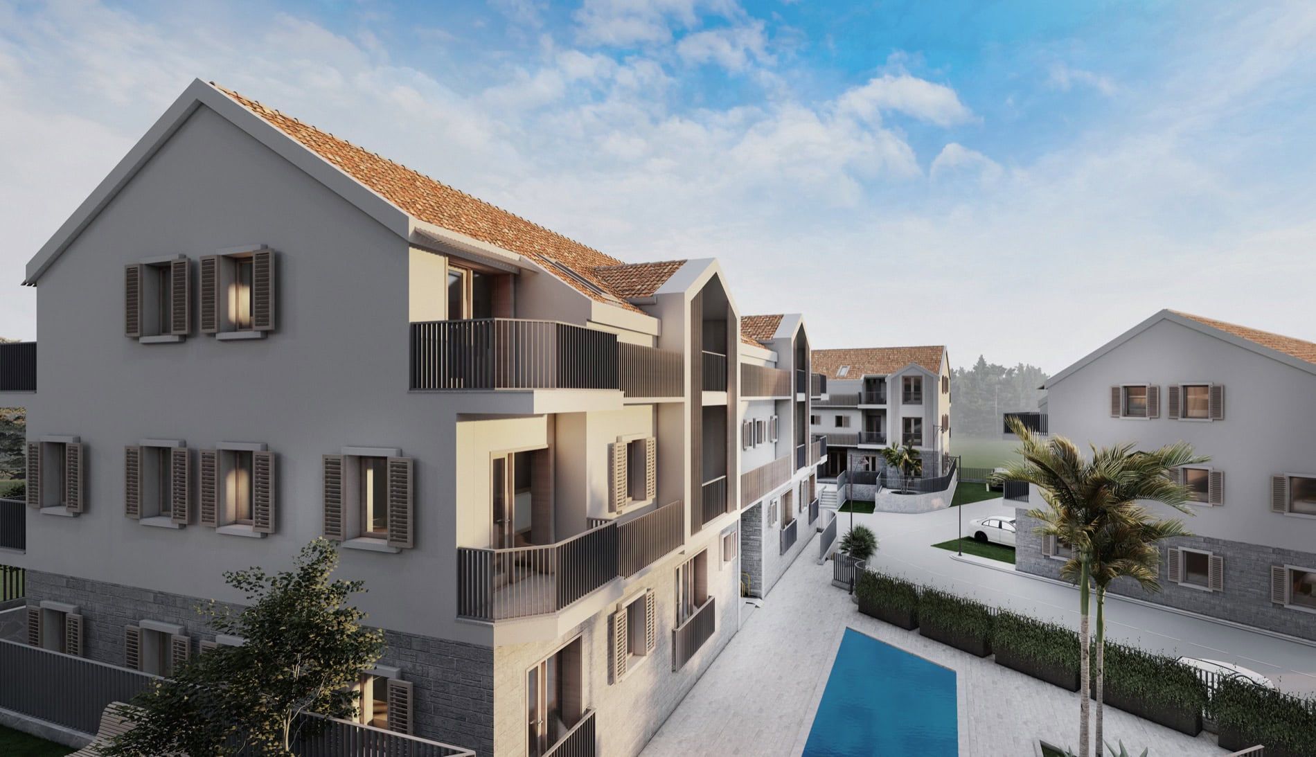 Modern residential complex in Risan, Montenegro: low-rise buildings with tiled roofs, balconies, and a swimming pool.