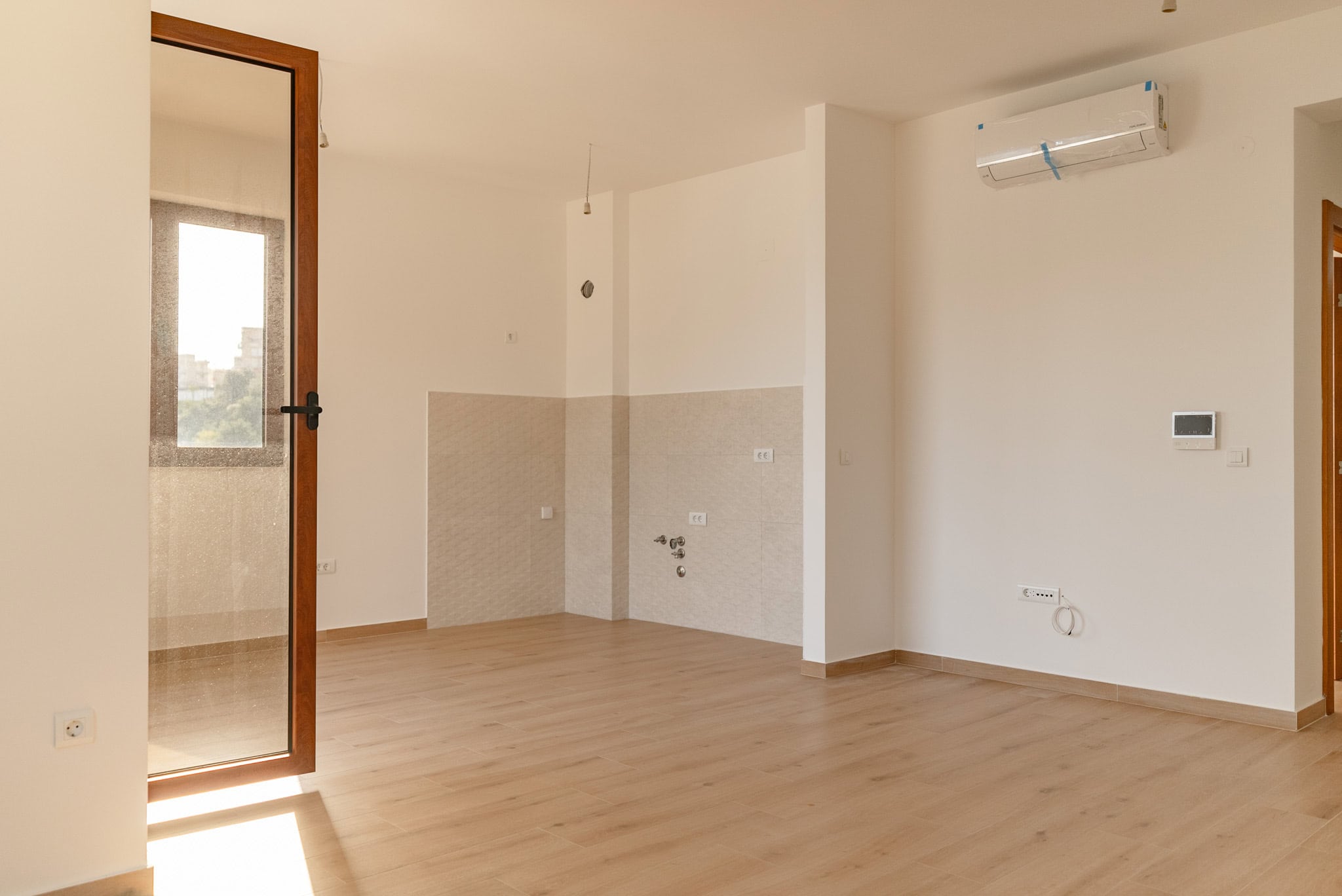 Bright living room with kitchen area and air conditioner in a new apartment, Budva, Montenegro.