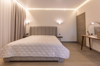 Modern bedroom with a double bed and a vanity table in a villa in Becici, Montenegro. Stylish interior.