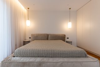 Modern bedroom with a double bed and built-in wardrobe in a villa in Becici, Montenegro. Designer interior.