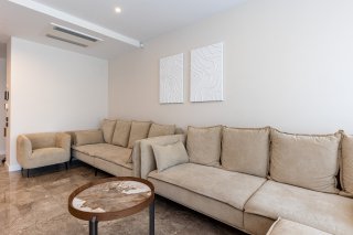 Bright living room with beige sofas and marble flooring in a villa in Becici, Montenegro. Modern interior.
