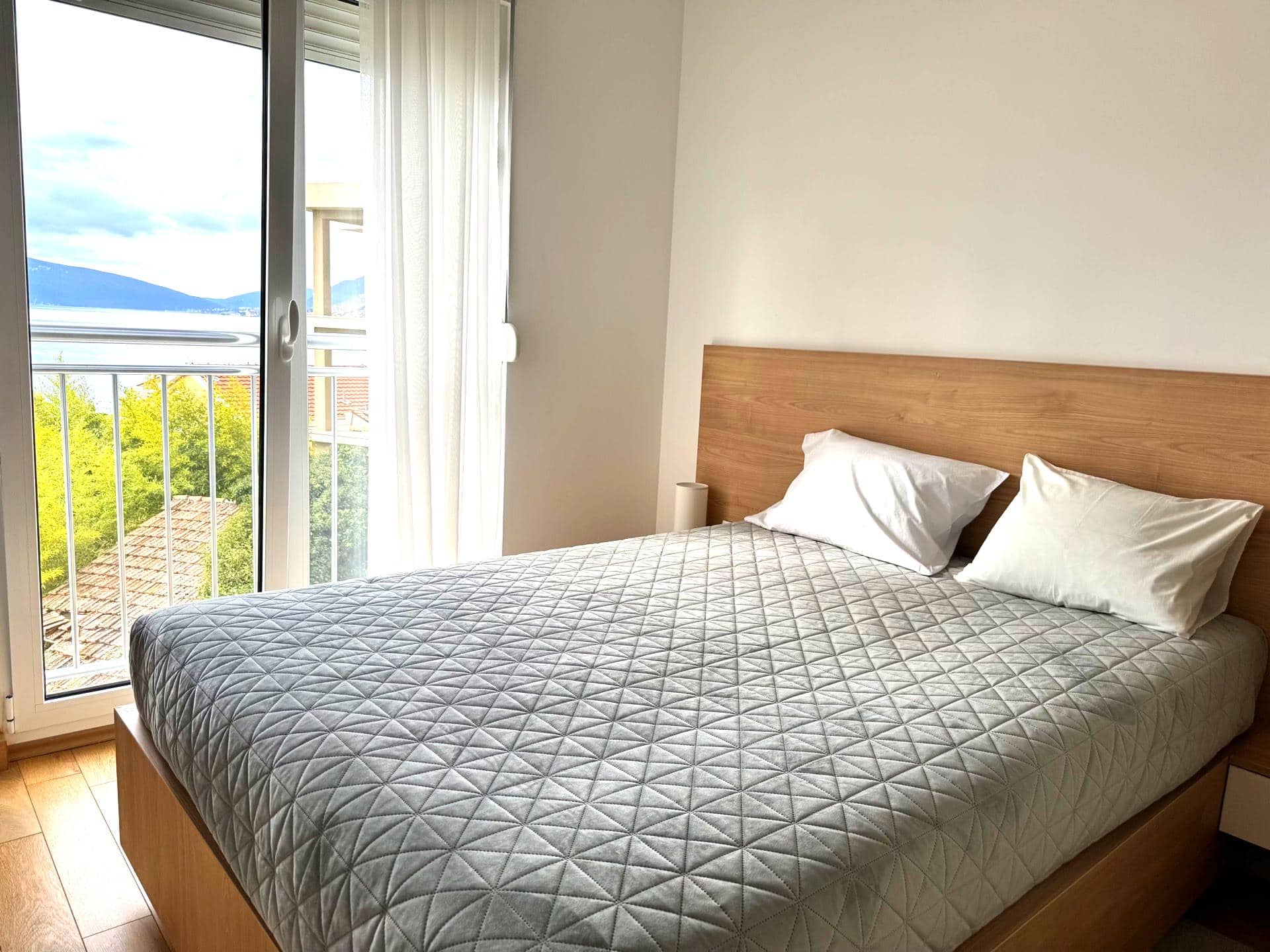 Bedroom with a double bed and panoramic sea view in an apartment in Tivat, Montenegro.