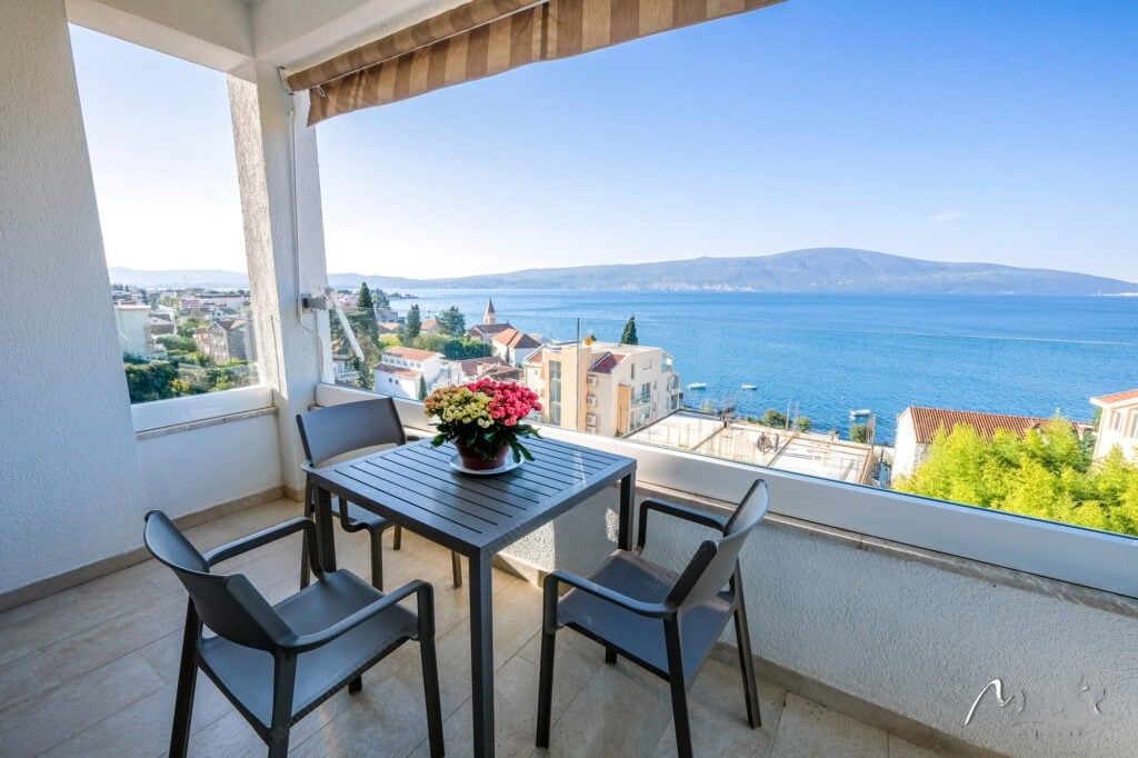 Terrace with furniture and panoramic sea and mountain views in an apartment, Tivat, Montenegro.