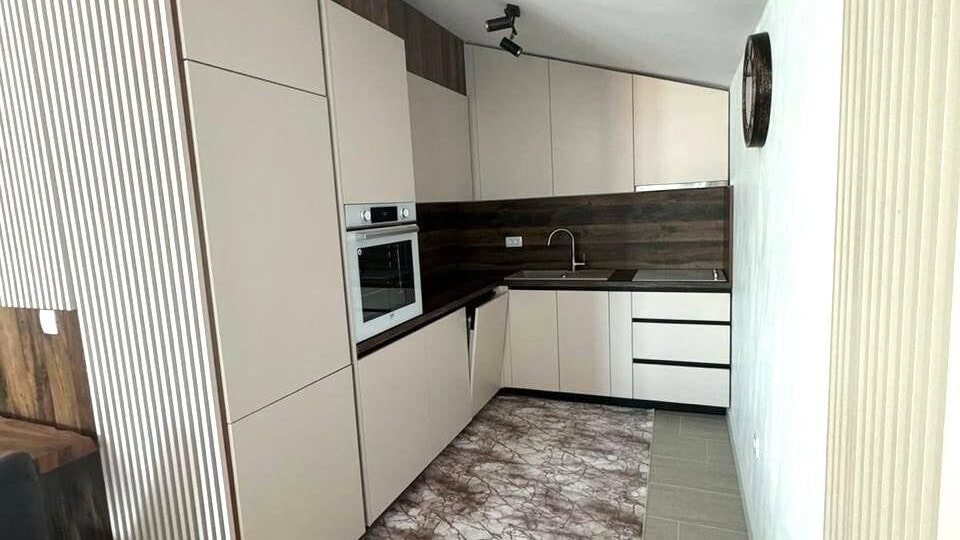 Modern kitchen in an apartment in Tivat, Montenegro: light fronts, built-in appliances, and wood-effect finishes.