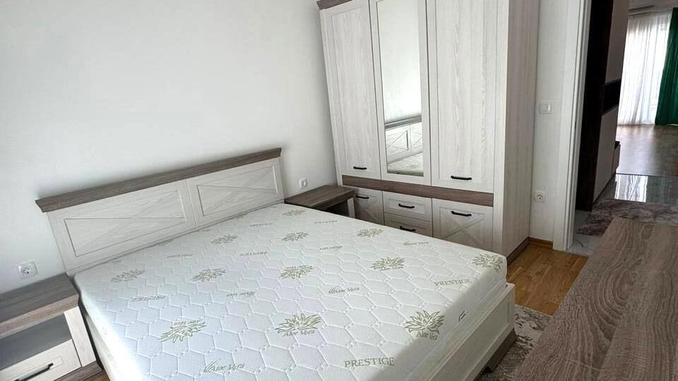 Bright bedroom with a double bed and wardrobe in an apartment, Tivat, Montenegro. Modern furniture in light tones.