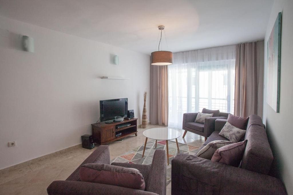 Cozy living room with soft furniture and access to the balcony in an apartment in Budva, Montenegro. Modern interior.