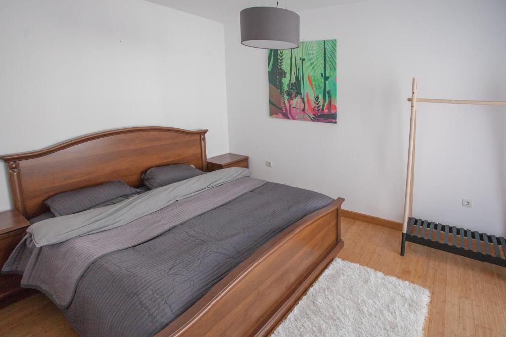 Bedroom in an apartment in Budva, Montenegro: a wooden double bed, a standing clothes rack, and a bright interior.