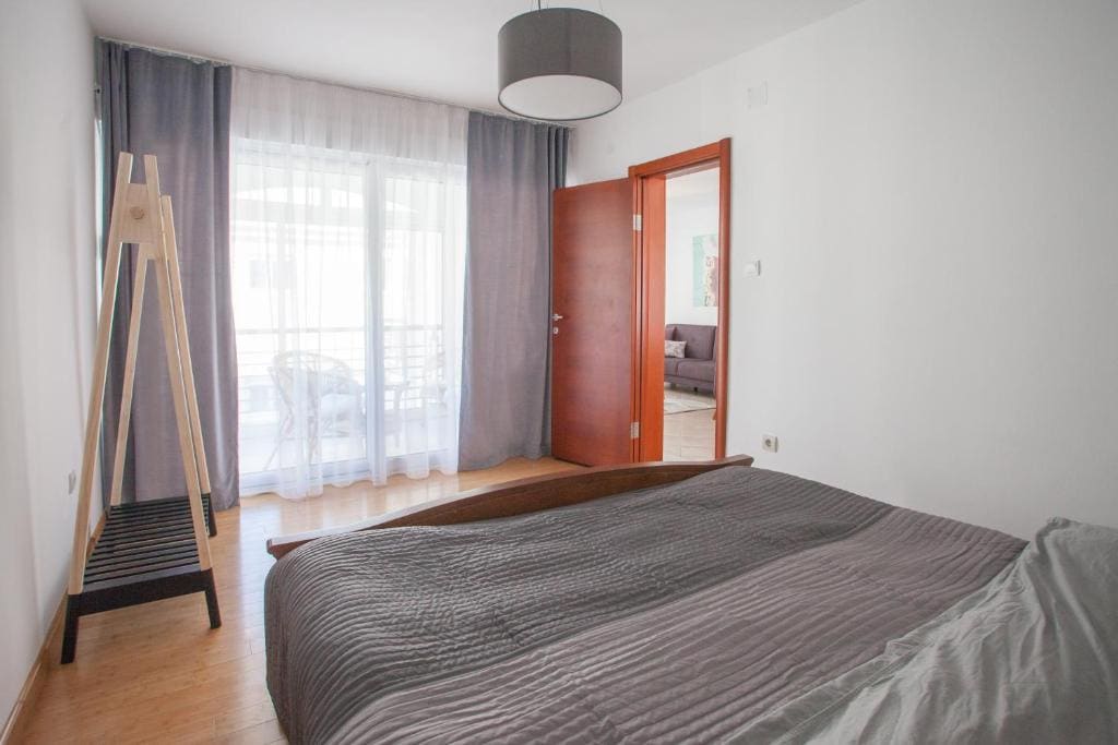 Bright bedroom with a double bed and access to the balcony in an apartment, Budva, Montenegro. Modern interior.