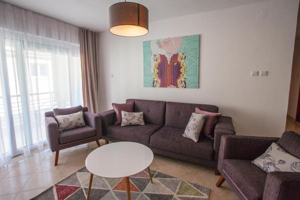Cozy living room with soft furniture and access to the balcony in an apartment in Budva, Montenegro. Modern interior.