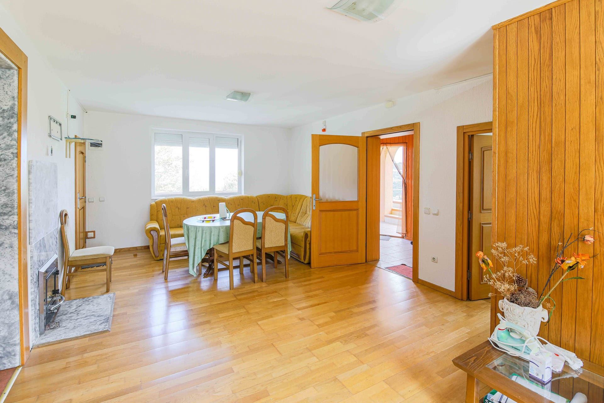 Living room with a fireplace, a seating area, and wood paneling in a house for sale, Utjeha, Montenegro.
