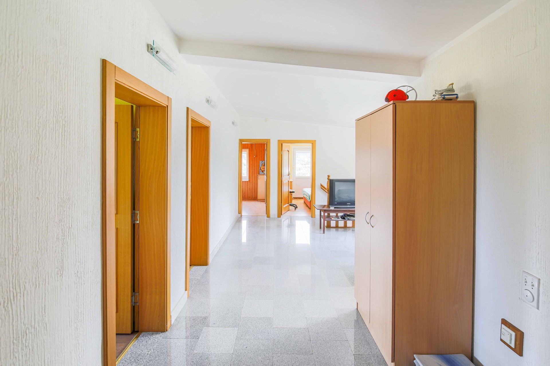 Bright hallway with marble floor and wooden doors in a house for sale in Utjeha, Montenegro.