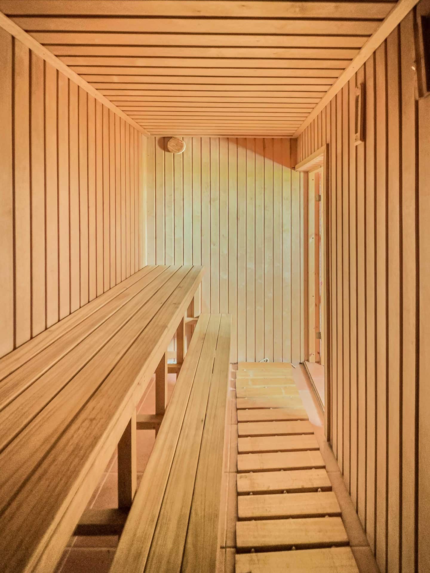 Interior of a modern wooden sauna in a house for sale, Utjeha, Montenegro: wall finish and benches made of light wood.