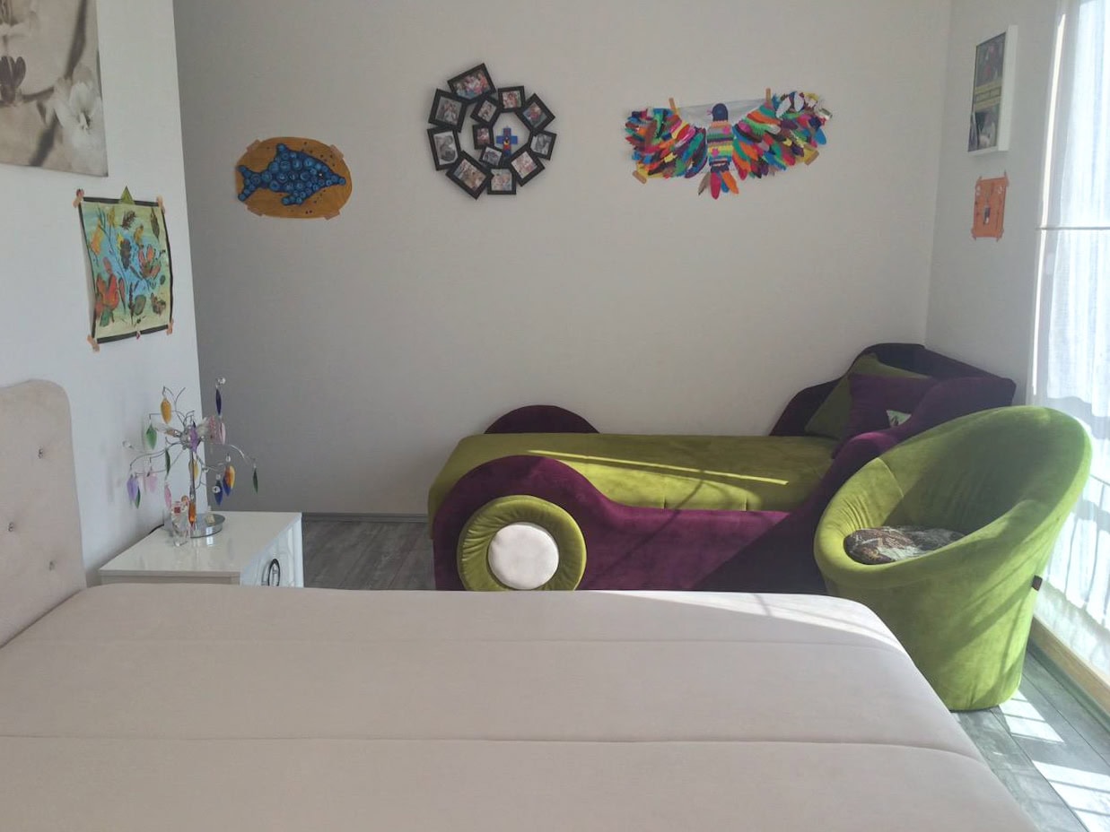 Children's bedroom in an apartment in Bečići, Montenegro: a bright room with beds, an armchair, and wall decor.