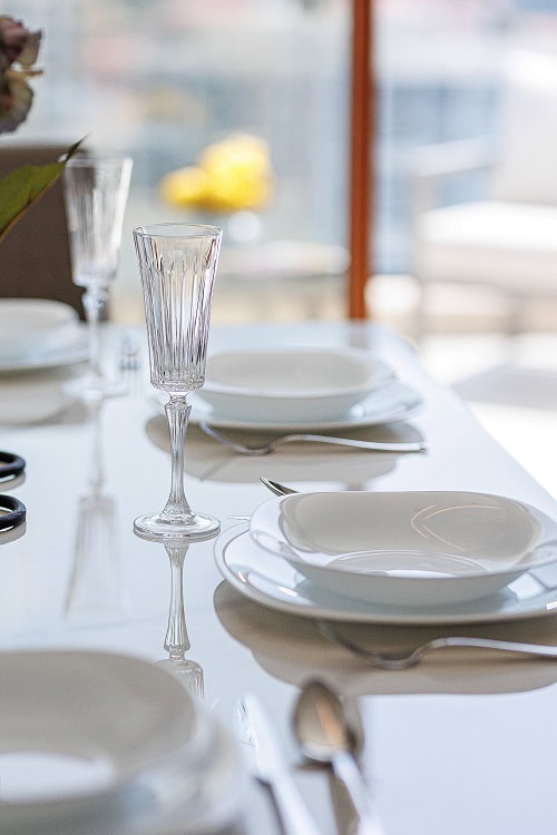 Dining table setting in a modern apartment living room in Bečići, Montenegro. Bright interior with a panoramic view.