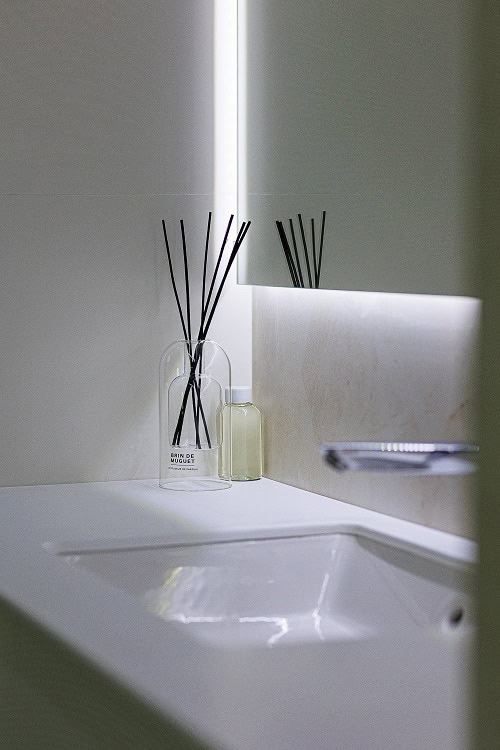 Modern bathroom in an apartment in Bečići, Montenegro: stylish sink, backlit mirror, and decor.