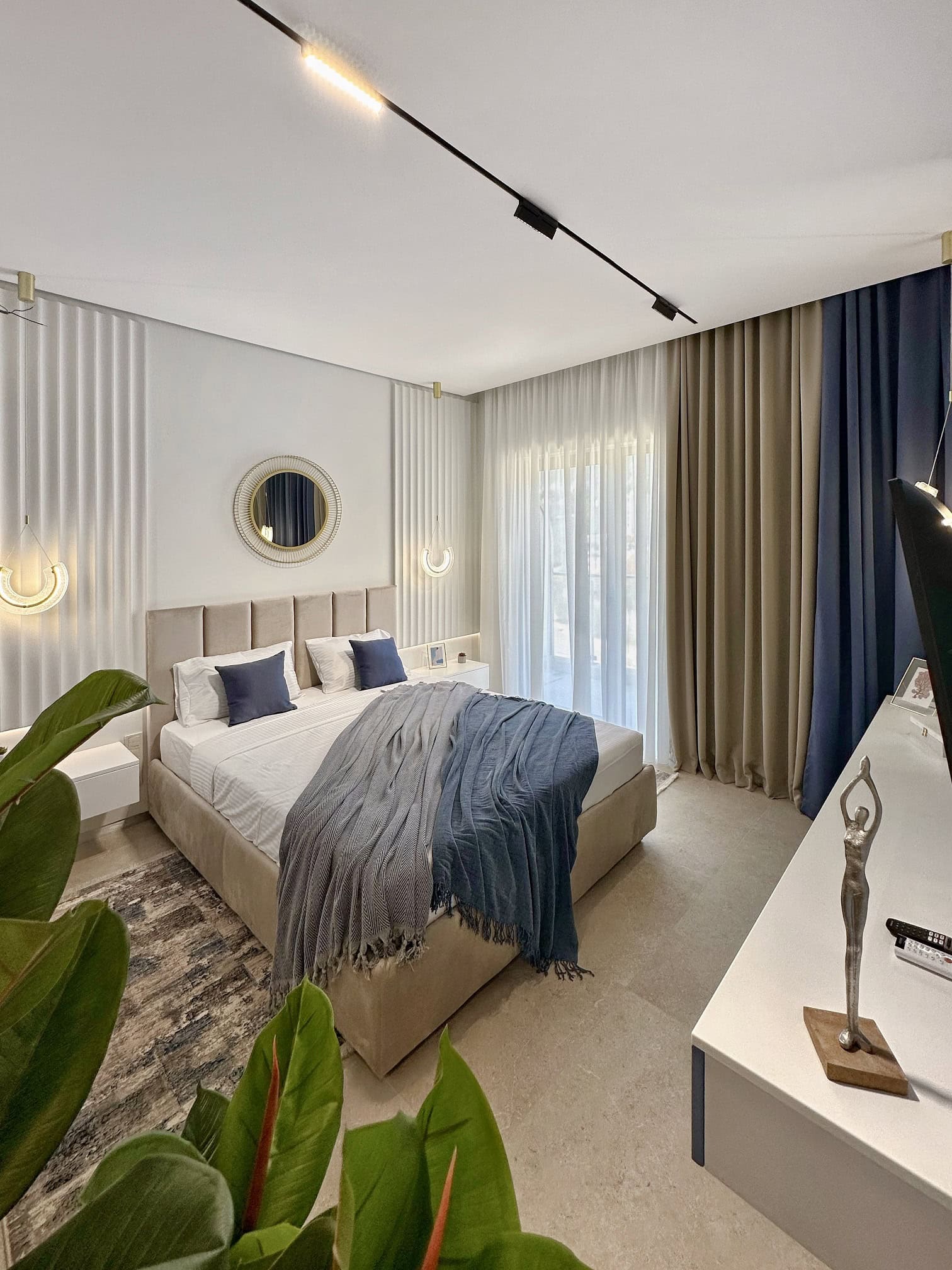 Modern bedroom in an apartment in Becici, Montenegro: double bed, designer lighting, and panoramic curtains.