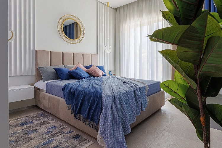 Modern bedroom with a double bed in an apartment, Becici, Montenegro: stylish interior, decor, and a houseplant.