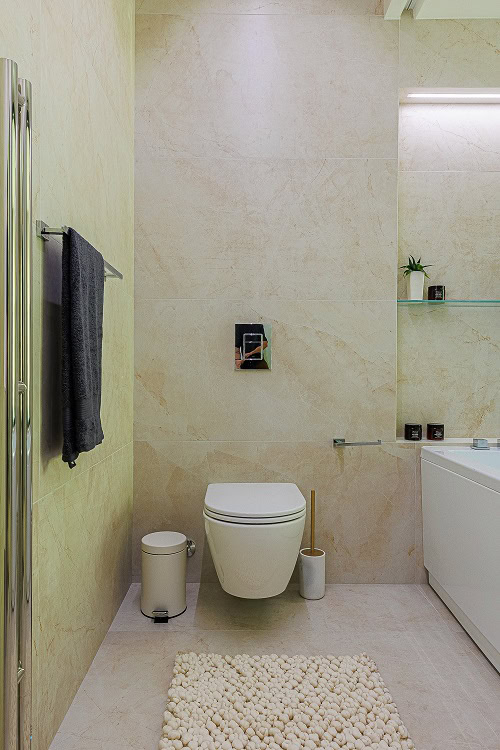 Modern bathroom in an apartment in Bečići, Montenegro: beige tiles, wall-hung toilet, and stylish decor.