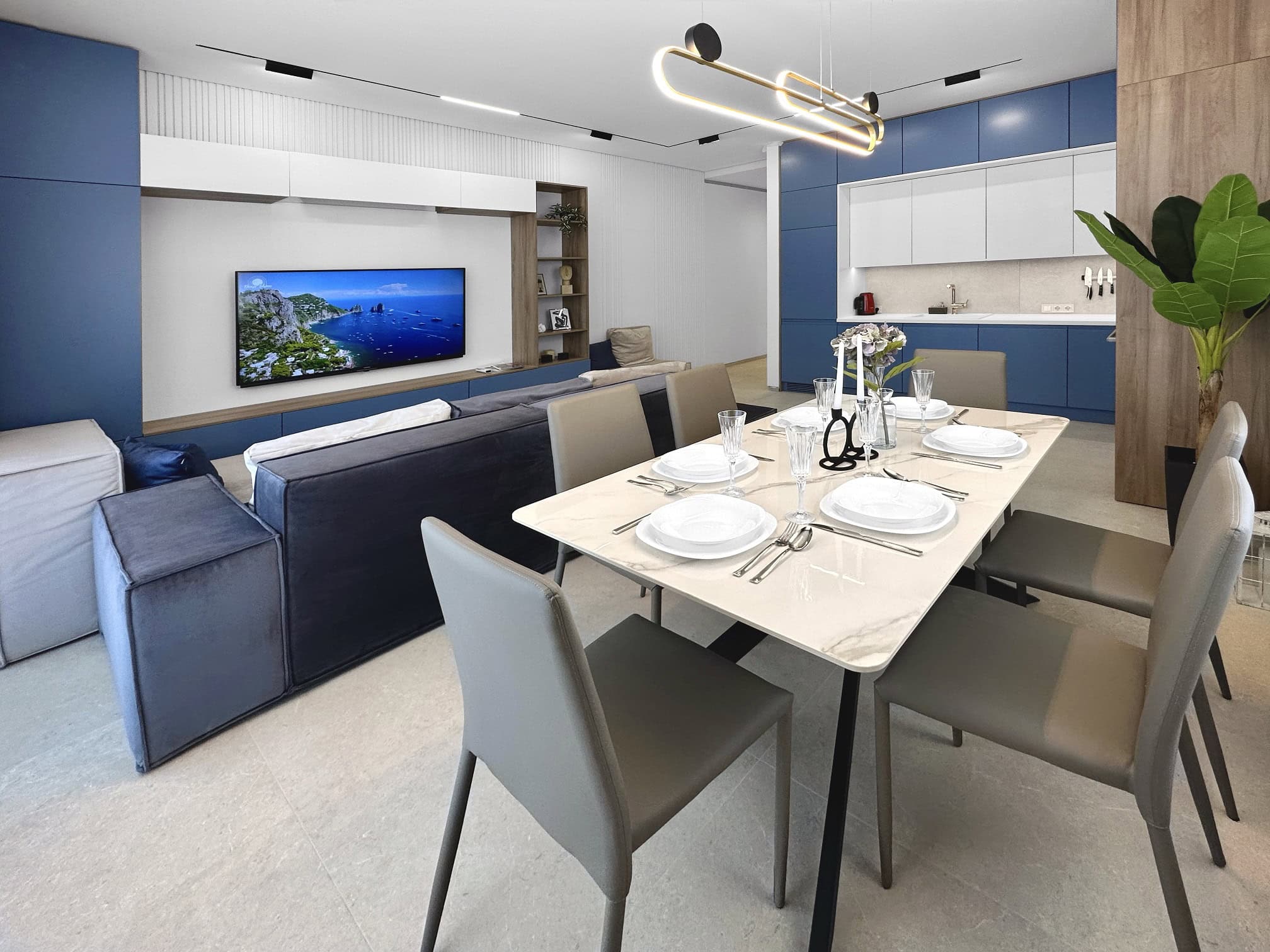 Modern living room with kitchen in an apartment in Becici, Montenegro: dining area, blue kitchen cabinetry, and TV area.