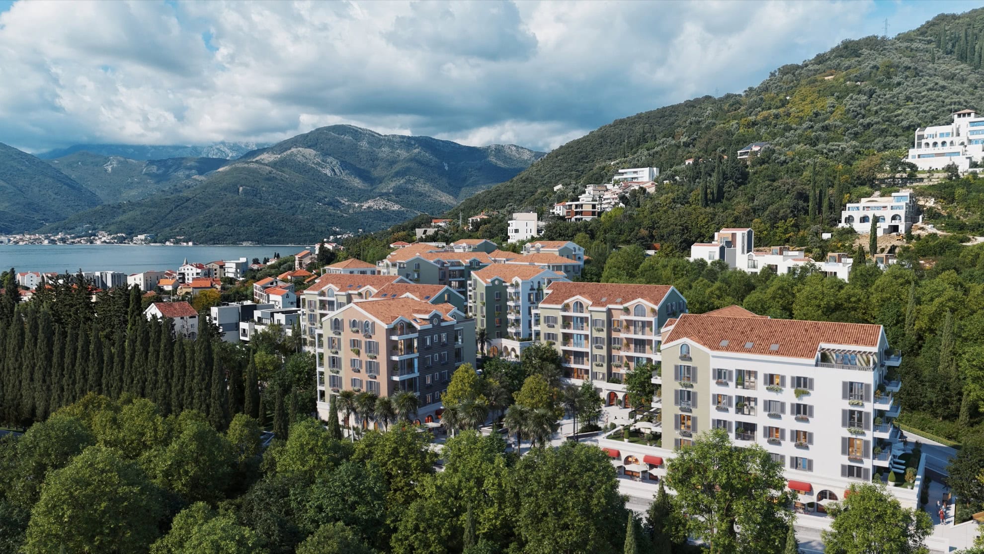 Residential complex with sea and mountain views in Tivat, Montenegro: modern houses with tiled roofs and a green garden.