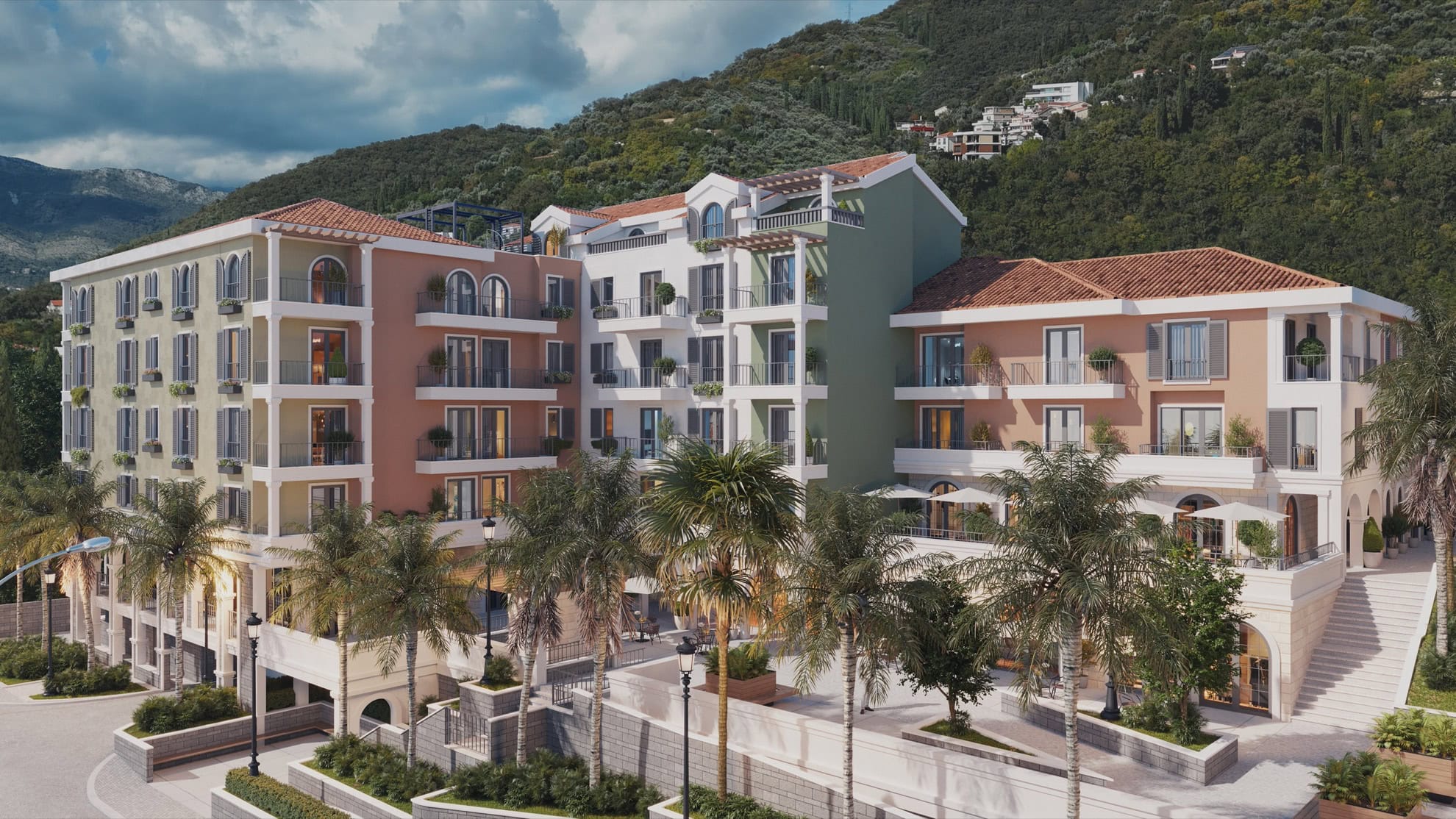 Modern residential complex with terraces and palm trees in Tivat, Montenegro: view of the luxury building facade near the mountains.