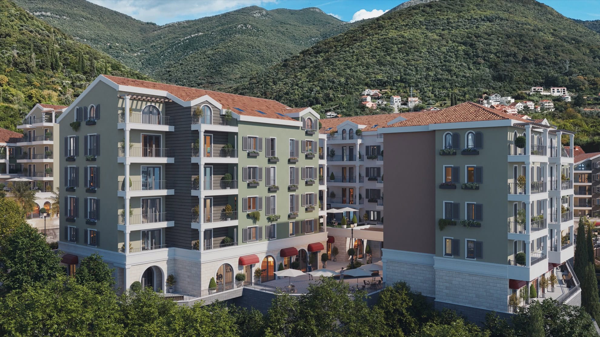 Modern residential complex in Tivat, Montenegro: multi-story buildings with balconies and mountain views, patios, and terraces.