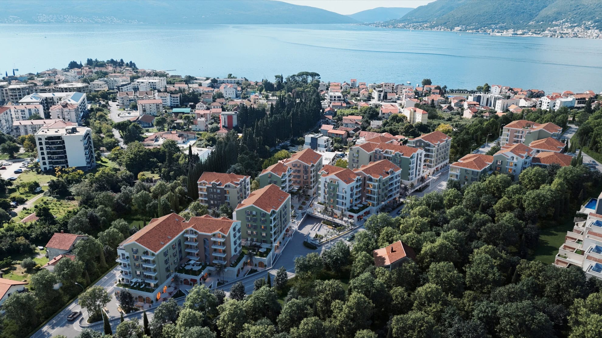 Aerial view of a residential complex in Tivat, Montenegro: modern houses with tiled roofs and panoramic sea views.
