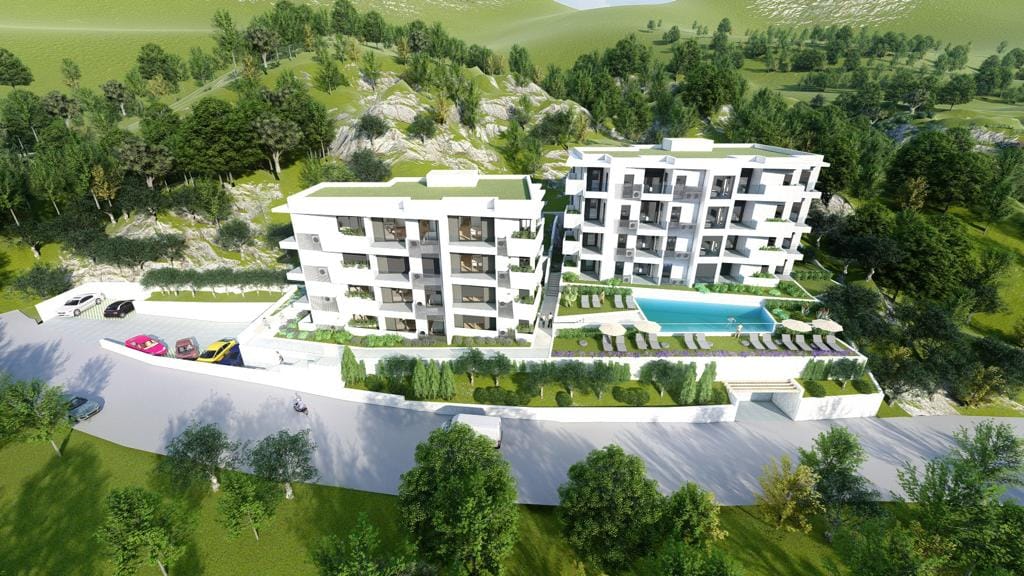 Modern residential complex with a pool and parking in Petrovac, Montenegro: aerial view of the buildings.