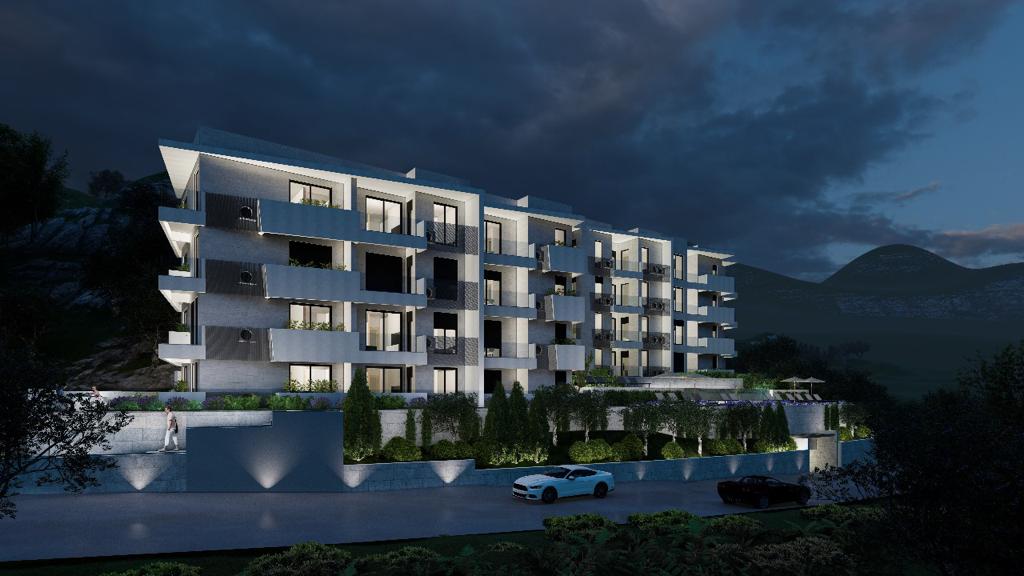 Modern residential complex in Petrovac, Montenegro: night view of the building with terraces, lighting, and a swimming pool.