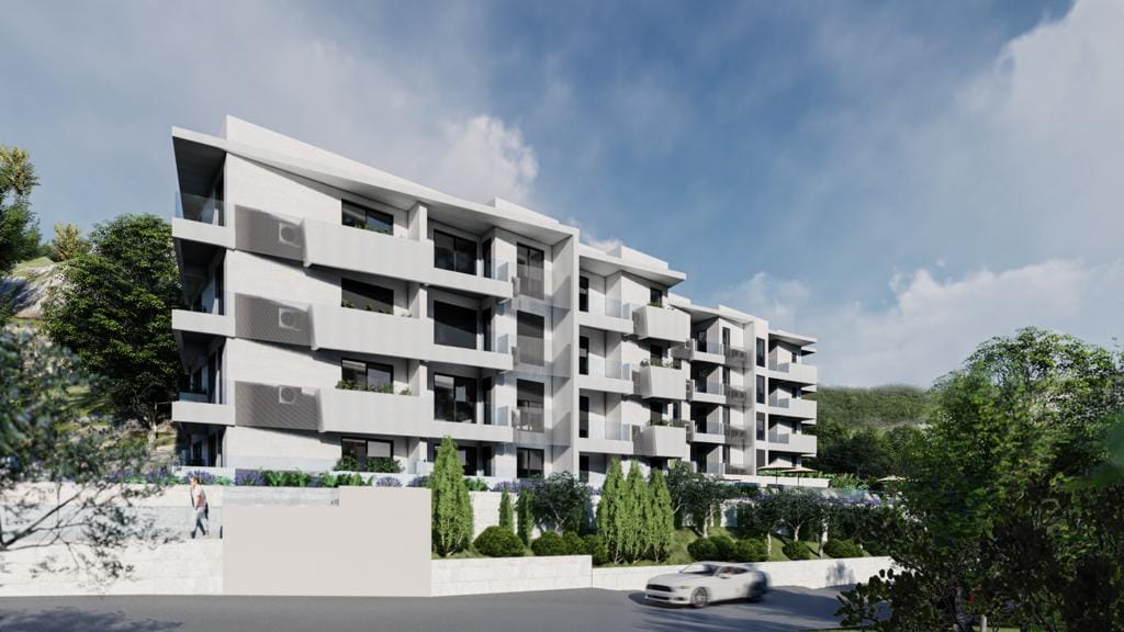 Modern residential complex with terraces in Petrovac, Montenegro: view of the building facade and landscaped grounds.