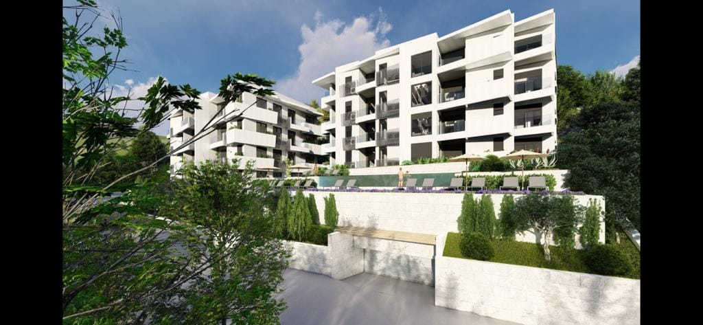 Modern residential complex with a pool and terraces in Petrovac, Montenegro: view of the building facade and surrounding area.