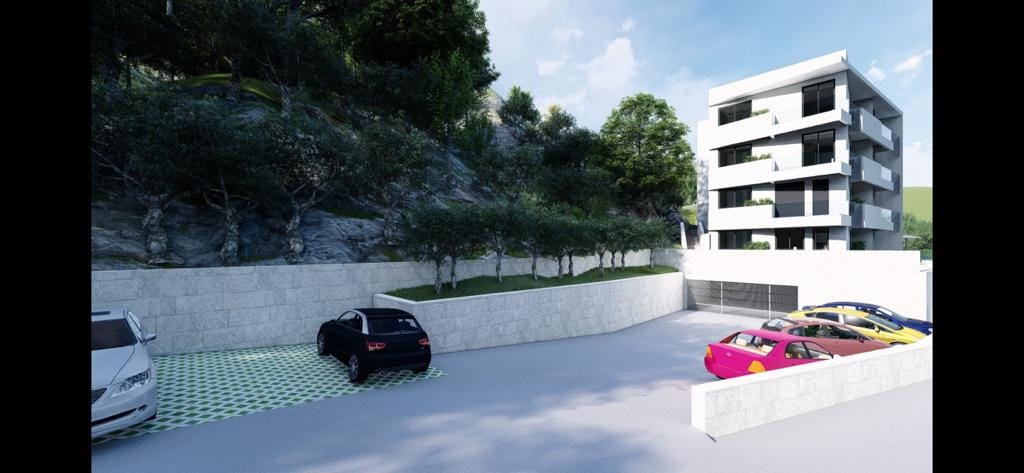 Modern residential complex in Petrovac, Montenegro: view of the building with parking and landscaped grounds.