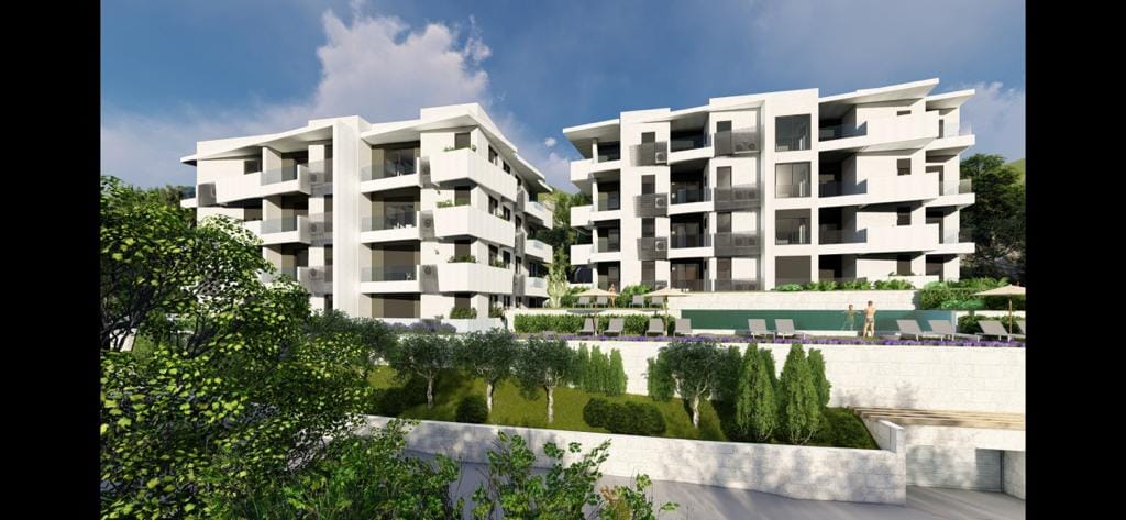 Modern residential complex with a pool and terraces in Petrovac, Montenegro — view of the building facades and landscaping.