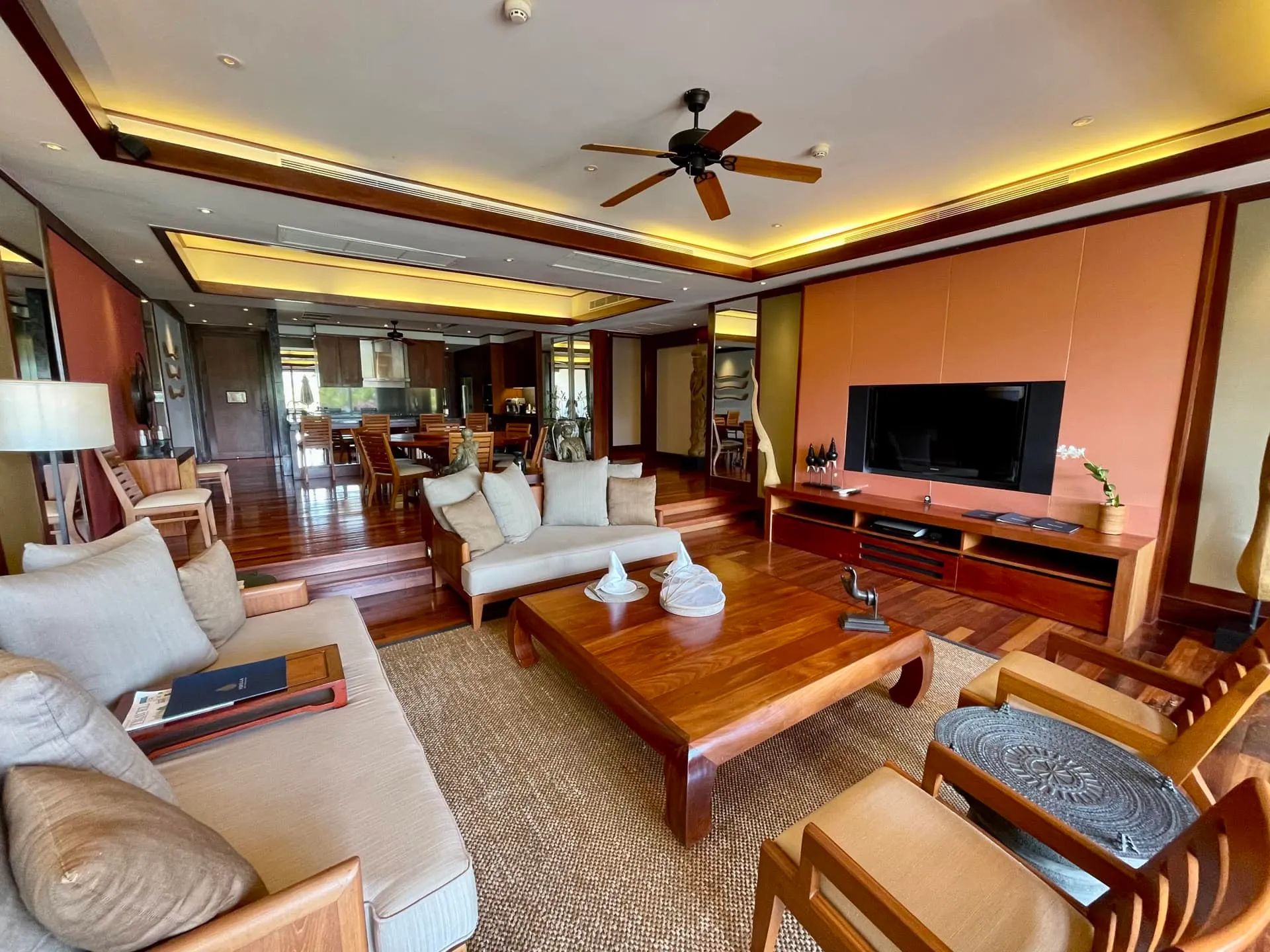 Living room featuring wooden furniture, sofas, a coffee table, and a wall-mounted television.
